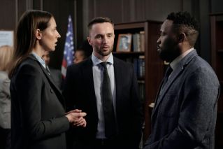 Group of business professionals engaged in a serious discussion inside an office environment.